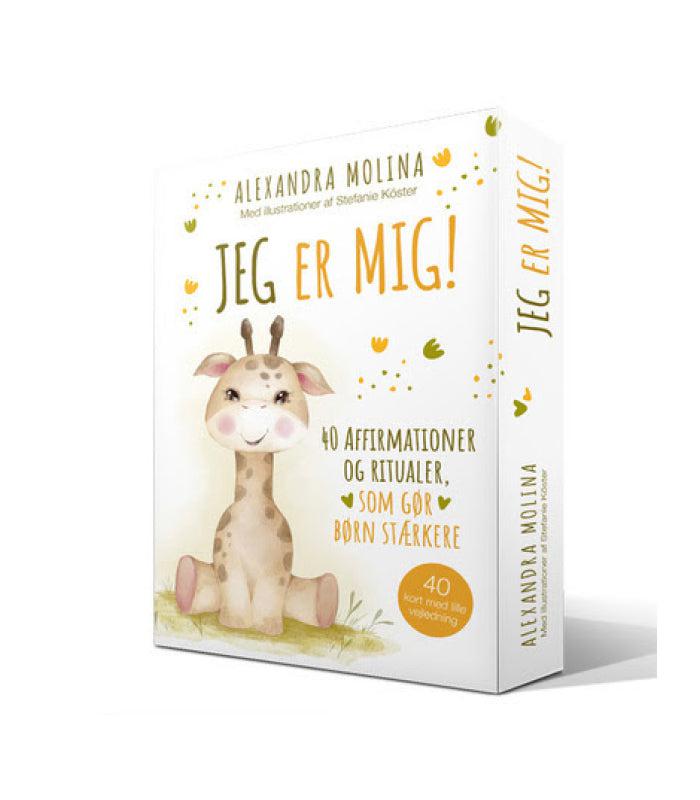 Produktæske med titlen Jeg Er Mig af Molina Alexandra med illustration af en glad giraf designet til børn indeholder 40 kort med affirmationer og ritualer der styrker børn. Pakken er farverig og kærkommen med blomster og naturmotiver.