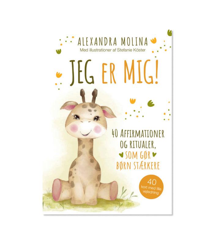 Illustreret omslag til orakelkortet Jeg Er Mig af Molina Alexandra viser en sød giraf med smilende ansigt og store øjne. Omslaget indeholder teksten Jeg er mig, 40 affirmationer og ritualer som gør børn stærkere. Der er også små farverige motiver som blomster og blade omkring teksten.