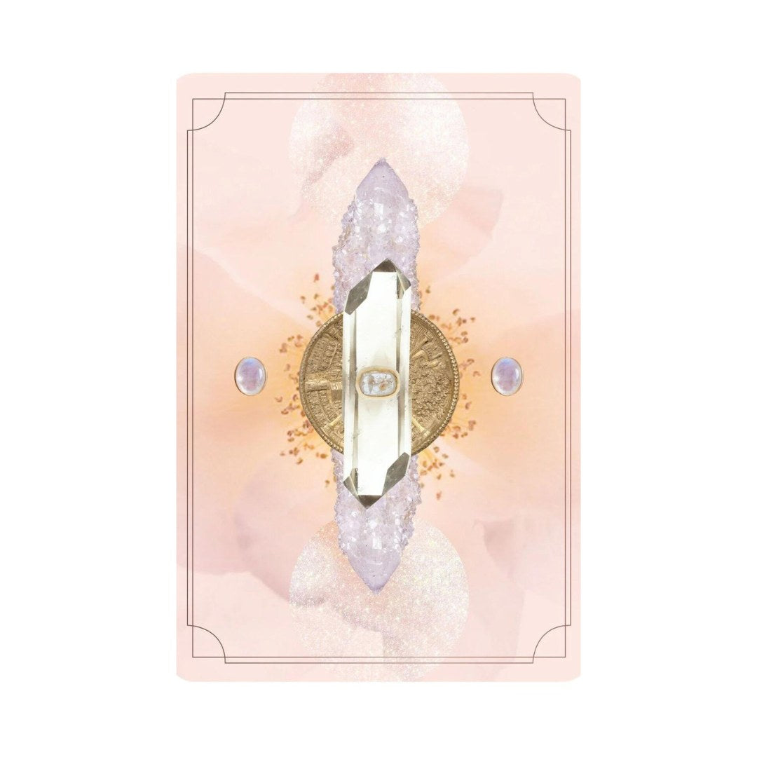 Billede af kortet Astral Realms Crystal prydet med en krystal i centrum omgivet af en gylden cirkel og to små ædelstene på en blød rosa baggrund med blomster detajler