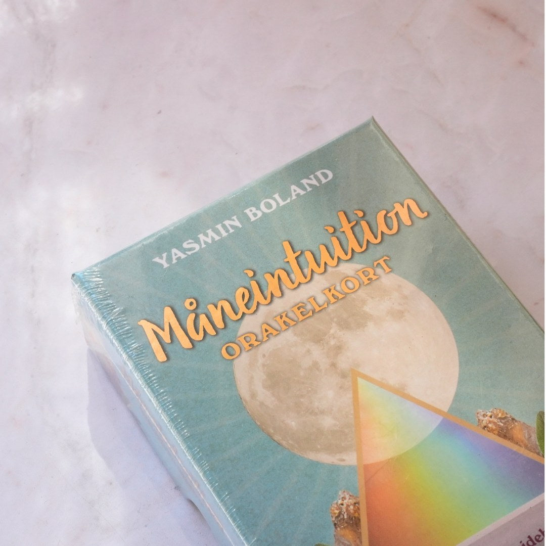 Måneintuition af Yasmin Boland orakelkort med en pastelblå baggrund og en stor måneillustration i midten samt en farverig pyramide nederste del af pakken