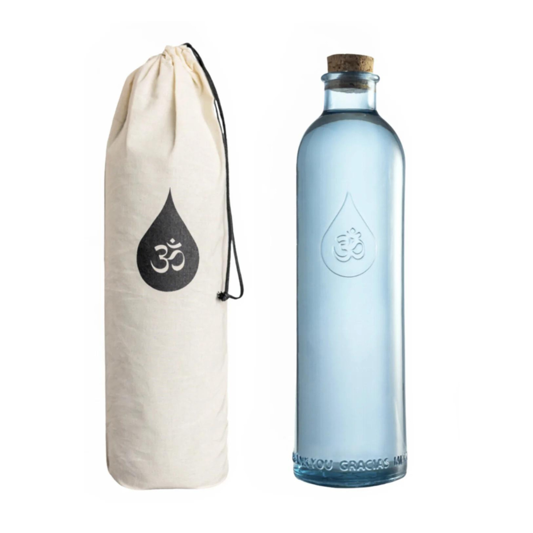 OHM vandflaske tillsammans med dess förvaringspåse i ekologiskt tyg med ett stiliserat vatten dropp-logotyp. Flaskans design är enkel och elegant med en kork av naturmaterial.