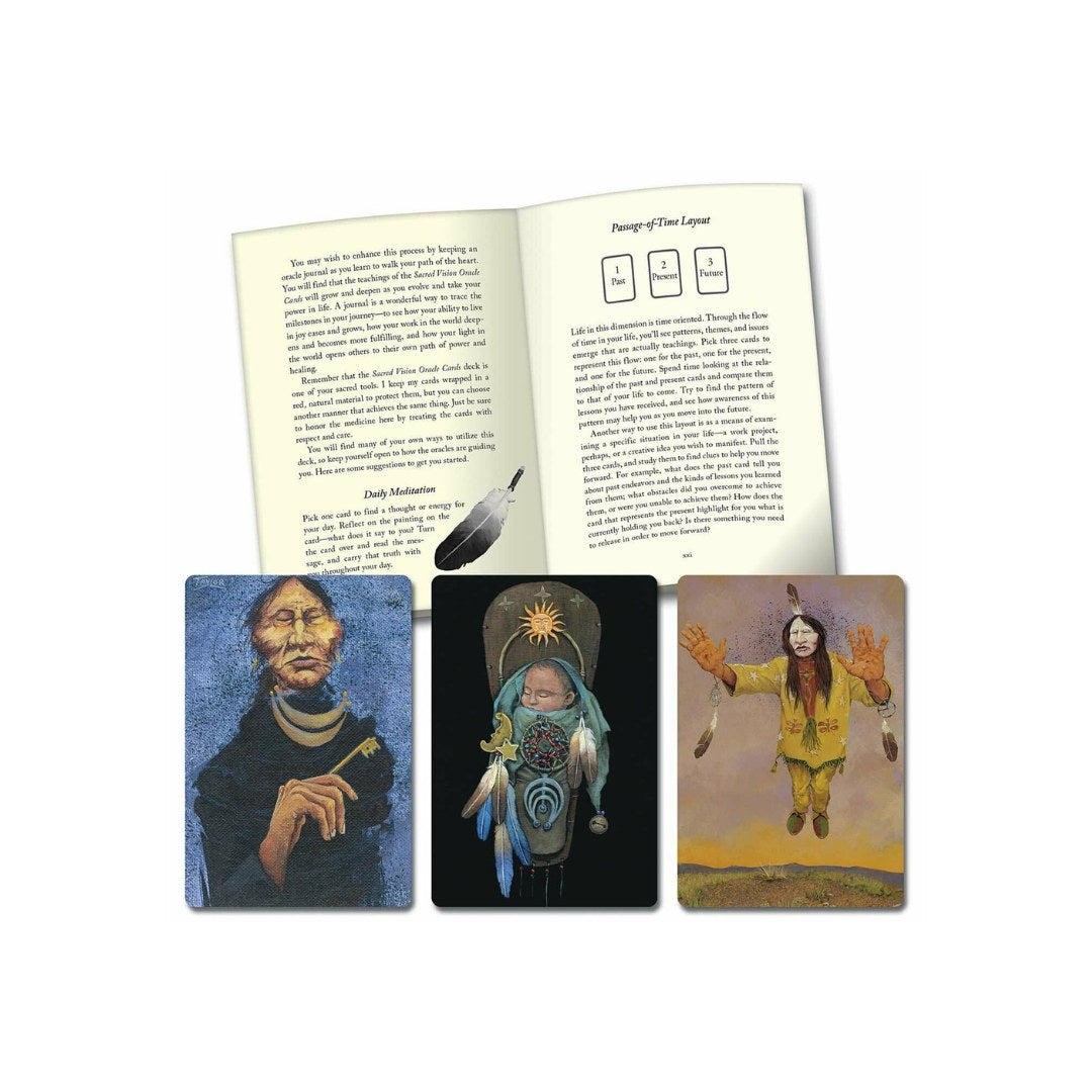 Produktbillede af Sacred Vision af Lynn V. Andrews med tre orakelkort placeret foran en åben bog. De tre kort viser forskellige kunstneriske illustrationer af spirituelle figurer og symboler, mens bogen indeholder tekst om meditation og vejledning til kortlæsning.