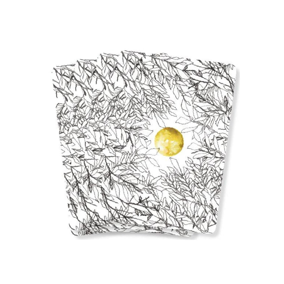 Et sæt orakelkort med et mønster af sorte blade og en gylden måne i midten, der symboliserer vejledning og støtte.