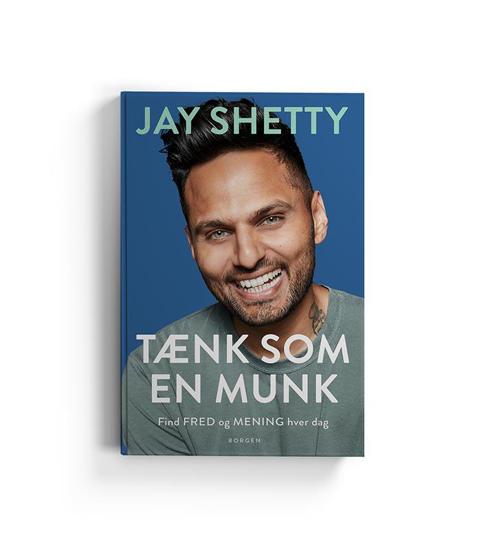 Boge omslag til Tænk som en munk af Jay Shetty med et portræt af forfatteren der smiler, titlen er tydelig i store bogstaver samt undertitlen om at finde fred og mening hver dag